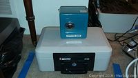 Photo showing the small blue toy-style safe sitting on top of the closed Sentry 2100 safe.