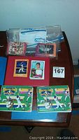 Multiple baseball cards in plastic zipper bags and two baseball card binders on table