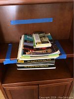 Photo of the collection stacked on a wooden shelf, showing several 'The Original Street Map Book' spiral-bound map books with other paperback map books on top.