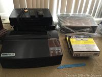 Overview photo showing all items including two Oreck XL air purifiers, two DVD players, and two boxed HD TV converters with remotes.