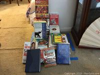 Full view of all items arranged in stacks; variety of books and magazines including cookbooks, self-help books, financial books, and religious texts.