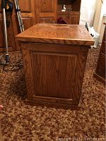 Side view showing paneled oak wood construction with rich grain and finish.