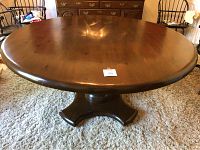 Top view of the round hardwood dining table showing the smooth polished surface and wood grain.