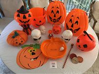 Photo showing all items including the pumpkin buckets, skulls, pumpkin plush, pumpkin candy dish, and other Halloween decorations on a table.