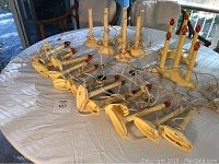 Photo of two multi-light and 21 single electric candle light fixtures on a round table with cords and plugs visible.