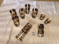 Full set showing glass pitcher, six tall glasses, and two short glasses on white cloth.