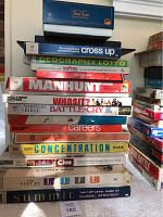 Stack of 16 assorted board games showing titles and box condition.