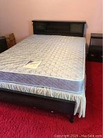 Full view of assembled queen bed with mattress and skirt