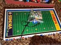 Top-down view of Tudor Super Bowl football game showing the playing field with Chiefs and Vikings end zones, and bag of miniature players on top of the board.