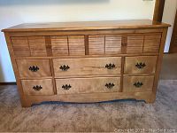 Front view of the solid birch wood dresser showing 8 drawers with mixed hardware and louvered style upper drawers.