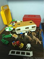 Full display of all items with camper, figurines, animals, furniture, and ladder on table