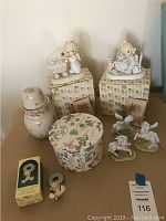Group photo of nine Precious Moments figurines including two boxed, various figures depicting children and angels, all light pastel colors, some on decorative boxes.