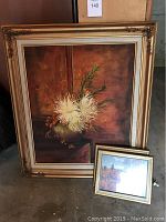 Large framed original oil painting of white flowers in vase with two smaller framed prints resting against it