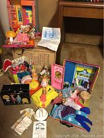 Full lot arranged on floor showing two Barbie house playsets, multiple dolls, accessories, and boxes