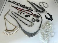 Full lot layout showing all necklaces and earrings in black, white, red, and silver tones