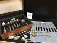 Open wood chest showing flatware in felt-lined compartments