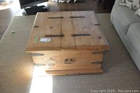 Front view of square pine coffee table with closed top, showing metal hinges and front handle