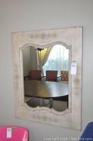 Front view of rectangular mirror with distressed pine wood frame showing carved floral detailing.