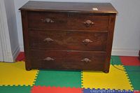Front view of the dresser showing all three drawers with carved handles and central lock areas