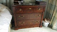 Front view of mahogany night stand showing three drawers and marble top