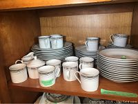Shelf displaying a full set of Gotham Fairfield china, including stacked plates, cups, and saucers.