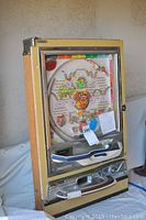 Full view of the vintage Nishijin pachinko machine showing its wooden and metal exterior with colorful game components.