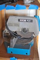 Front view of Ryobi 8 1/4 inch compound miter saw showing blade guard, power cord, and base.