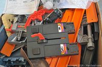 Photo of black motorized units with electric connectors and orange and gray tracks parts scattered underneath.