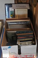 Box full of various picture frames and photo albums.