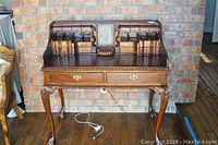 Full front view of two-piece secretary desk showing drop-front and cabriole legs