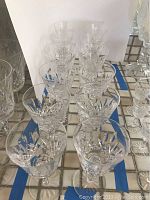 Photo showing the full set of 12 Waterford Lismore crystal wine glasses arranged on a surface, displaying the cut crystal pattern.