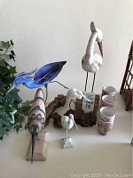 Overview showing all bird sculptures and ceramic cups arranged on a flat surface.