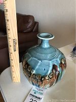 Porcelain vase standing next to a ruler showing a height of approximately 7.5 inches.