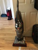 Front view of Hoover Max Performance WindTunnel upright vacuum cleaner standing on wooden floor.