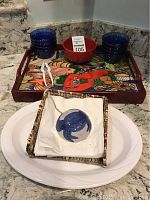 Set showing cobalt dishes stacked and the lobster tray with a white platter and napkin holder containing a cobalt dish and a lobster nutcracker tool