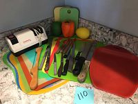 Photo showing knives, cutting boards, electric sharpener, and wooden spatula arranged on a countertop