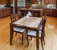 Full view of rectangular wood table with tile inlay and four chairs in kitchen setting