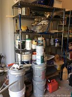 Full view of metal shelving unit loaded with various storage items for context, shelving itself included in sale not contents