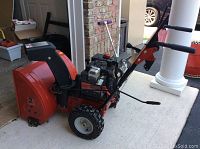 Side view of snow blower showing overall condition, engine, auger housing and chute