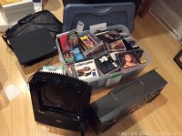 Overview photo showing IBM ThinkPad laptop with case, plastic container full of music CDs, Panasonic boombox, and karaoke machine.