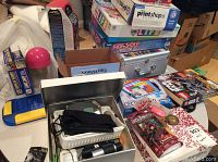Overview of toys and board games including LEGO, Pokémon, Harry Potter, and boxed board games. Various packaging and loose items visible.