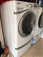 Washer and pedestal shown at an angle next to dryer
