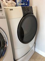 Side angle view of white dryer next to matching washer