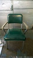 Front view of the Steelcase green vinyl mid-century modern armchair with metal frame.