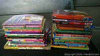 Two stacks of colorful children's paperback books on a flat surface, showing the variety of titles and some visible covers and spines.