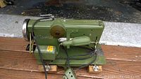 Front angled view of the green Vigor Elli sewing machine showing motor and foot pedal cable.