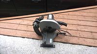 Complete view of heavy duty chop saw on wooden surface with power cord visible, showing overall condition and build.