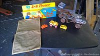 Overview of all items on table including EZ-Tracer box, toy cars, roller skates, and Boy Scout bag.