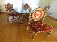 Set of six dining chairs around a glass table, showing the overall condition, wood frame, and patterned upholstery.
