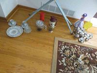 Full view of the items spread on the floor including tea set, doll, coin bank, beverage containers